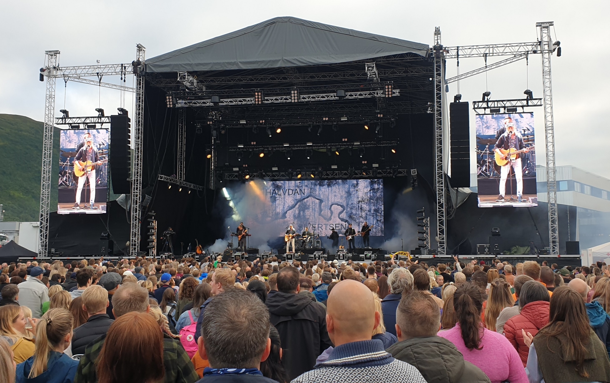 Bilde mot en festivalscene, vi ser publikums bakhoder og Halvdan Sivertsen på scenen langt unna.