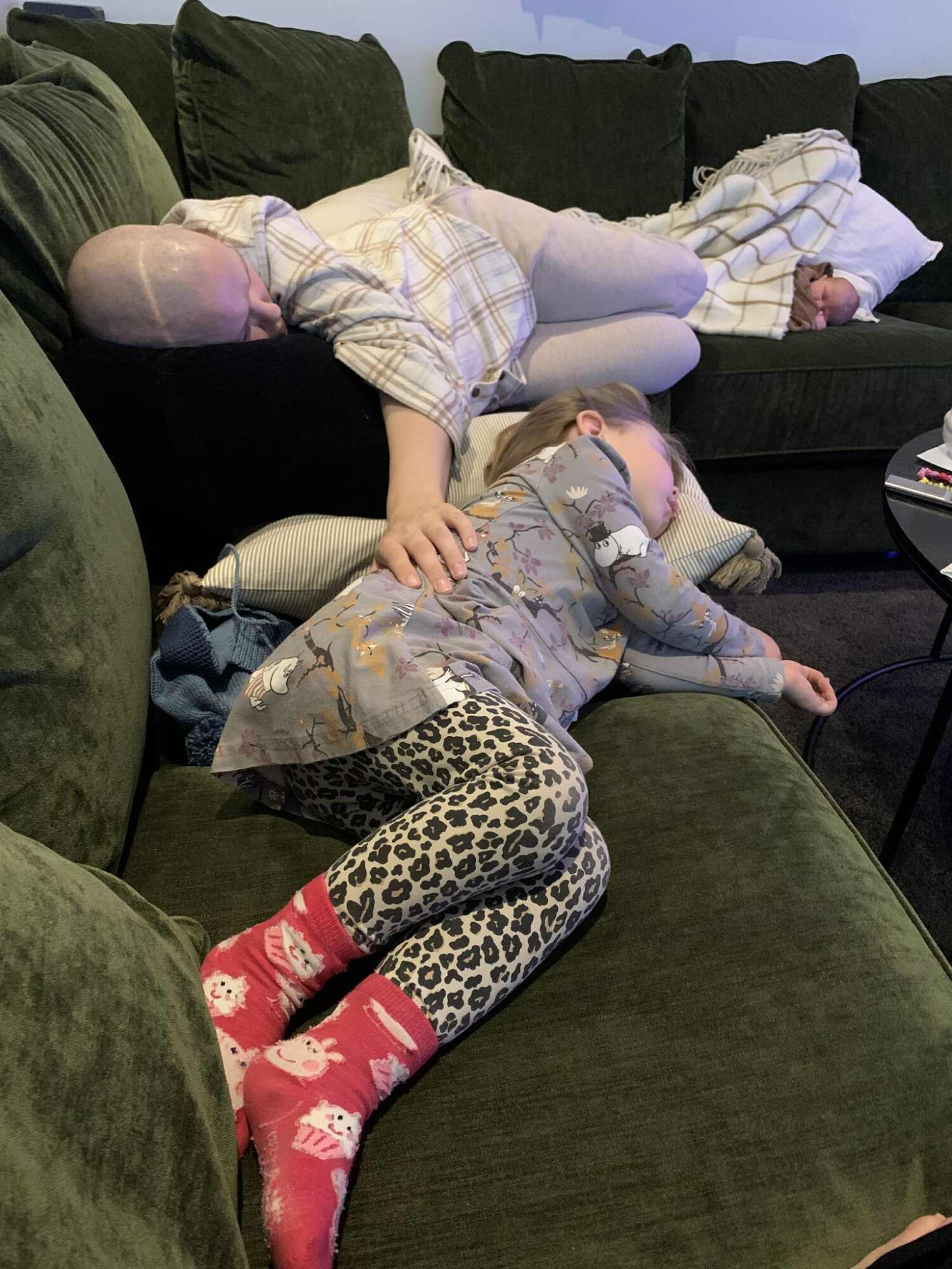 Hege og hennes to barn ligger og slapper av på sofaen.