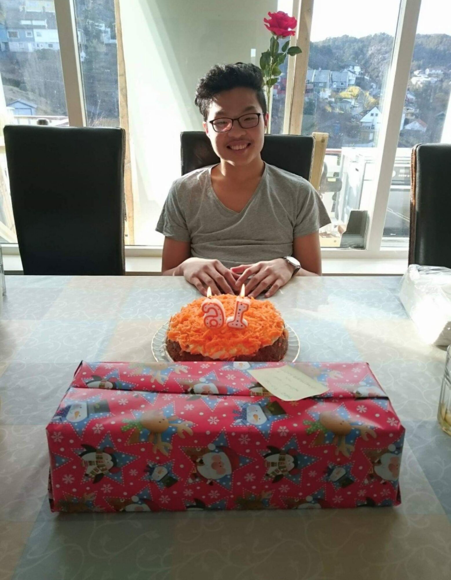 Thomas med kake og gave foran seg.