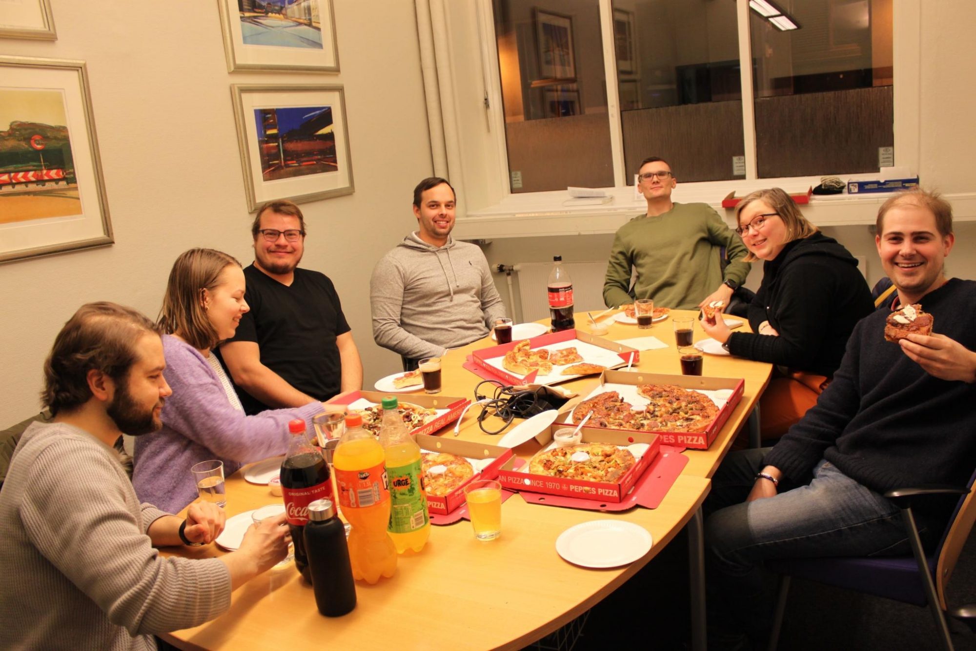 Bilde av deltakerne på årsmøte 2019 som spise pizza